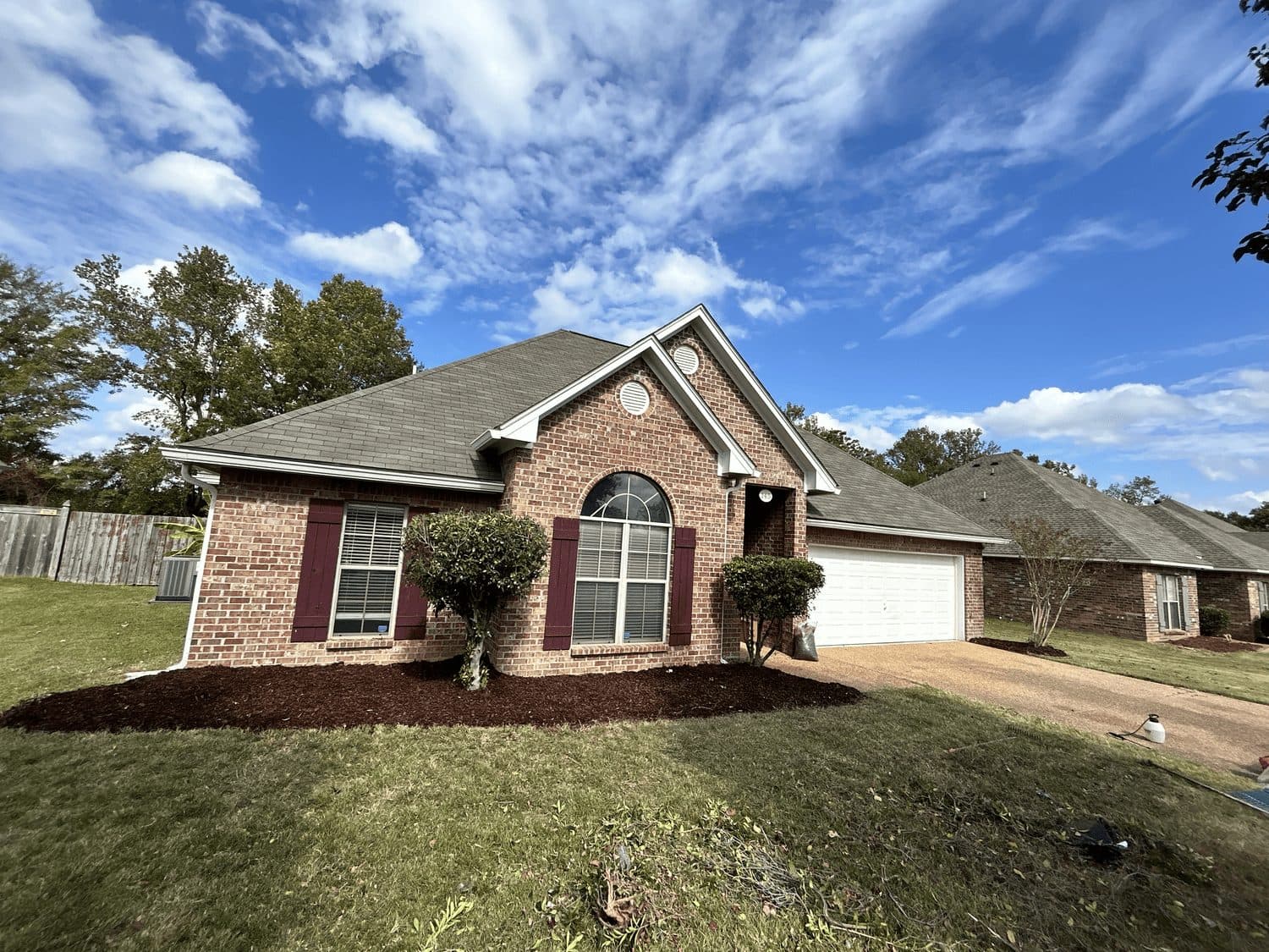 Fresh mulch beds at a red brick home