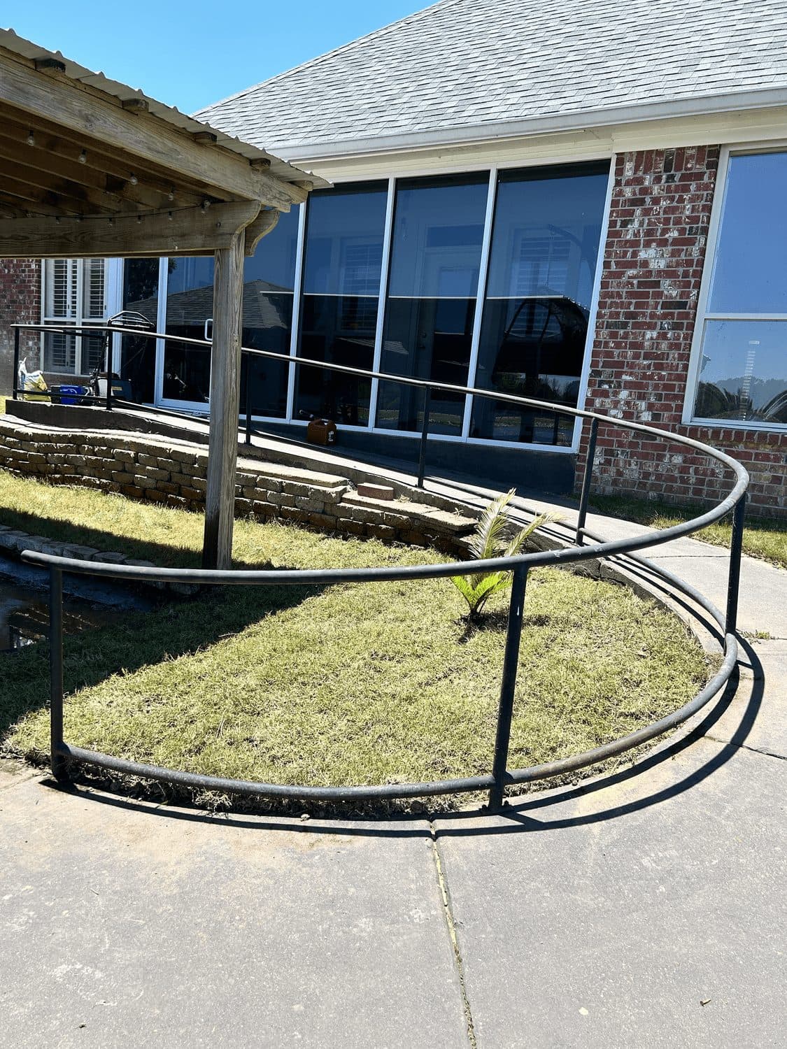 Curved bed with a stone border and handrail outside a commercial building
