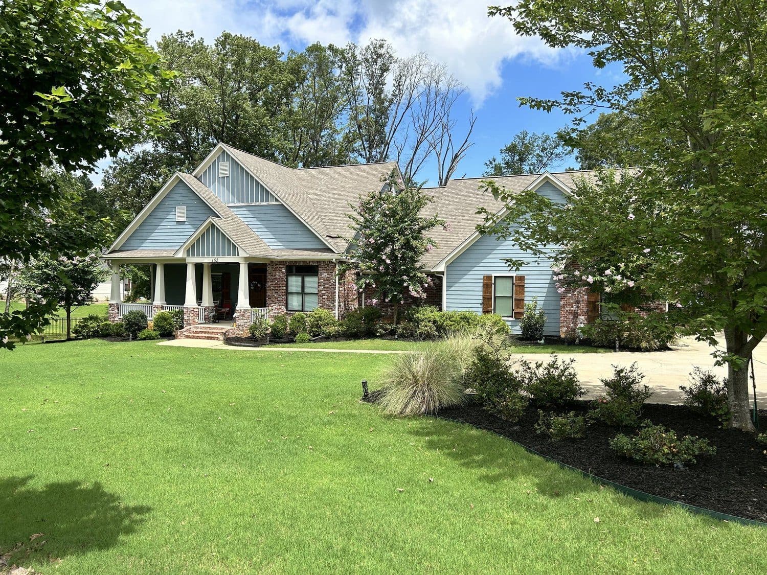 Wide green lawn and ornamental grasses at a craftsman-style home