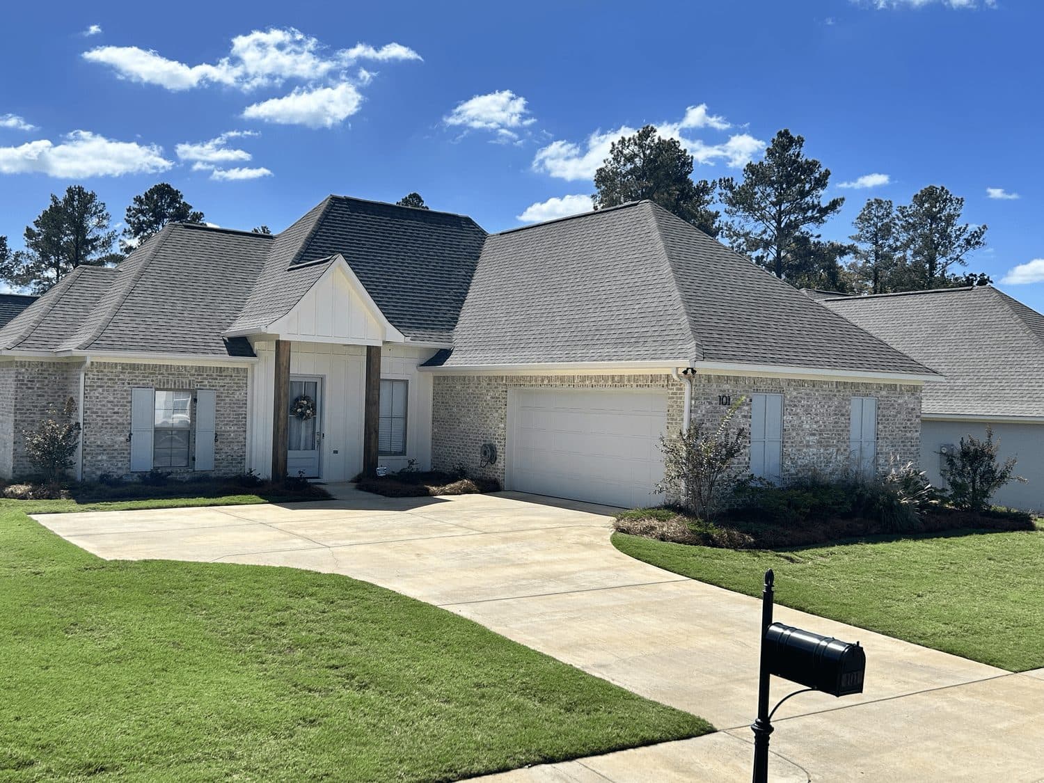 Trimmed beds and edged lawn at a gray brick home