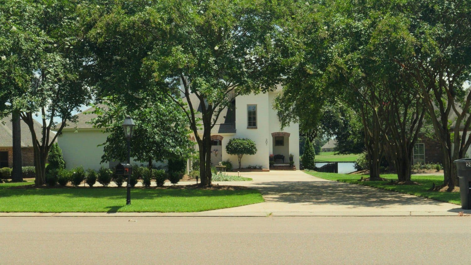 Tree-lined front lawn mowed and edged along the street